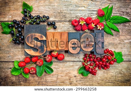 sweet, word set with vintage printing blocks surrounded by assorted berry fruits