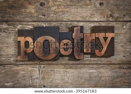 poetry, single word set with vintage letterpress printing blocks on rustic wooden background