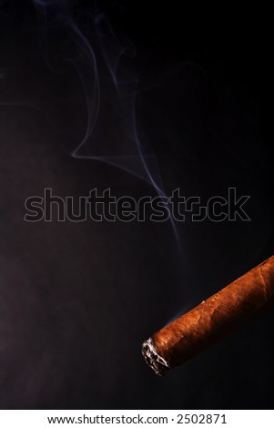 burning cuban cigar with smoke