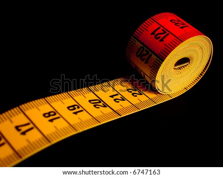 rolled-up tape measure on black background