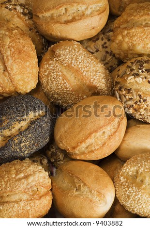 background of various sorts of small white bread rolls, with poppy seeds, flax seeds, sesame, cheese crust