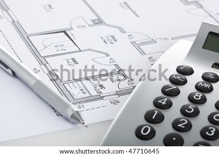 mechanical pencil and calculator on blueprint of floor plan, close up