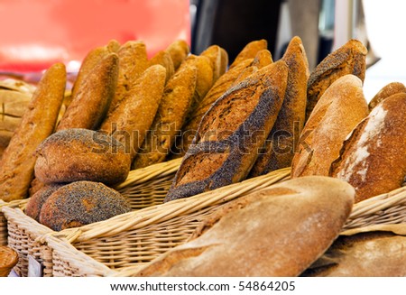 various kinds of rustic bread in baskets being offered at a french market