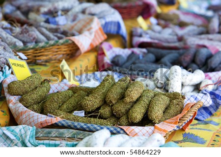 variety of sausages being offered at market stand in the Normandy, herb coated sausage in focus