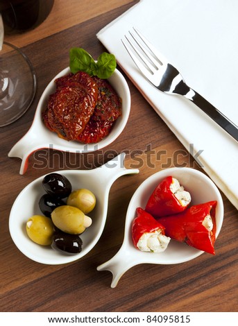 variety of antipasti with marinated dried tomatoes, black and green olives, stuffed red peppers