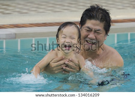 Grandfather with granddaughter in the pool at my home.