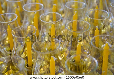 Yellow candles in glass jars.