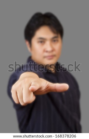 Asian business man pointed the finger on a gray background, focus on the finger of model.