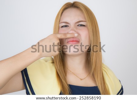 Beautiful woman hands off the nose because smell rotten.