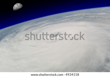 View from space of a giant hurricane over the ocean with moon in background.