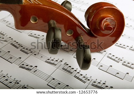 Closeup of violin scroll with sheet music