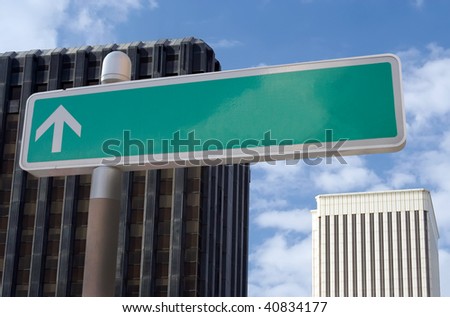 Blank street sign with an arrow located in a business district.  Suitable for superimposing your own text.