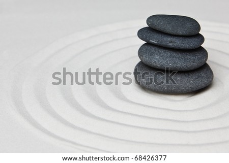 Close-up of a pile of stones on raked sand in a Japanese ornamental or zen garden.