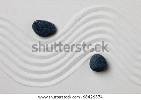 Close-up of two stones on white raked sand in a Japanese ornamental or zen garden.