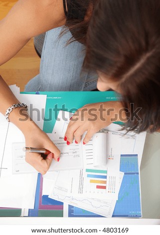Busines woman\'s hands and check book.