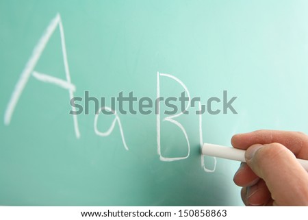 Writing alphabet on chalkboard