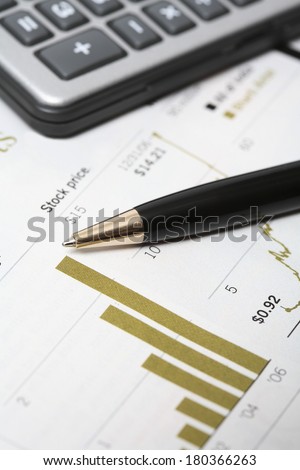 Still life of stock market stats calculator and pen
