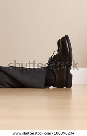 Legs and feet of lying passed out business man
