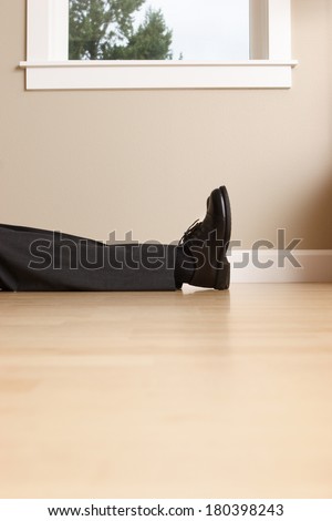 Legs and feet of business man laying passed out on floor