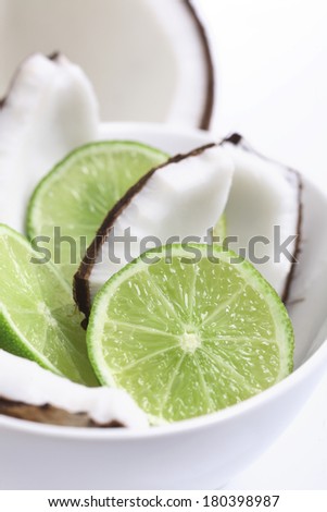 Coconut and lime in white bowl with white background