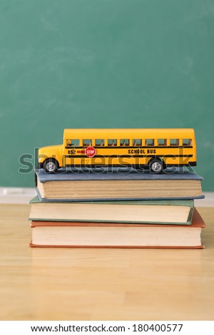 School education still life of toy school bus on stack of books
