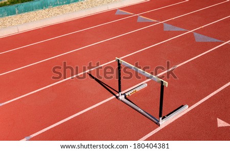 Single hurdle on red sports track
