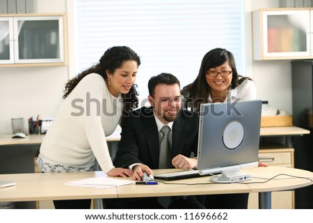Three business people looking at computer