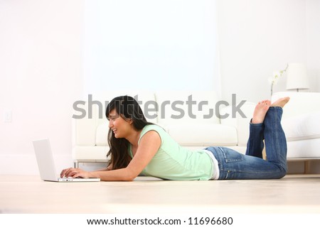 Young woman laying on floor using laptop