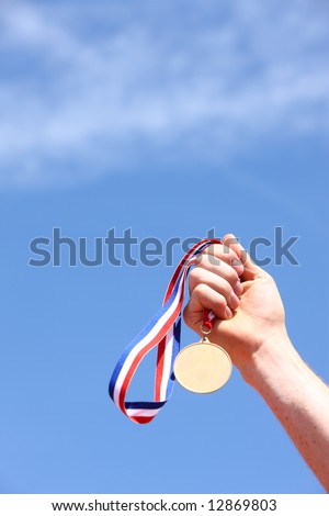 Hand holding gold medal