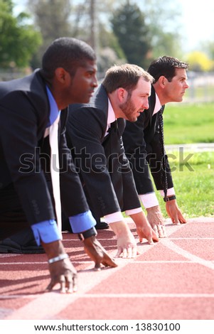 Businessmen lined up on track starting line