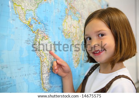 Elementary school student smiles by world map