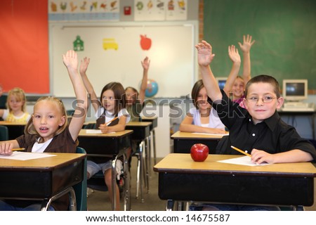Elementary school students raising hands