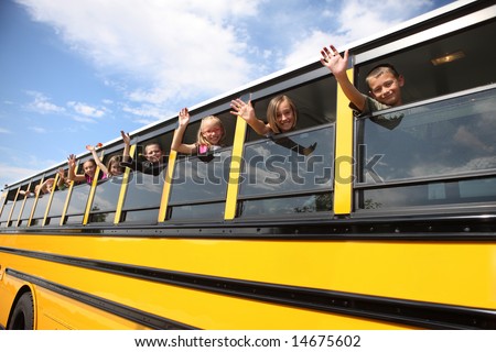 Elementary school students waving from school bus