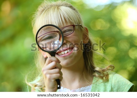 stock photo : Girl looking through a magnifying glass