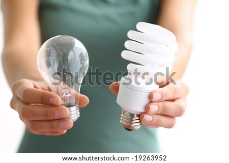 Traditional Light Bulbs on Hands Holding Traditional And Energy Efficient Light Bulbs Stock Photo