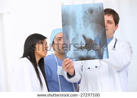 Group of medical personnel looking at x-ray
