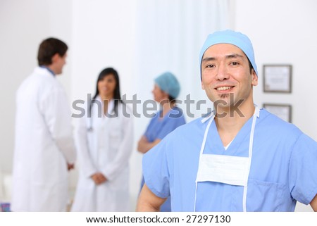 Portrait of surgeon with other medical personnel in background