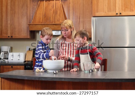 Mom and young boy\'s cooking together in kitchen
