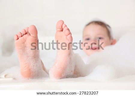 stock photo Young boy with feet sticking out of bubble bath