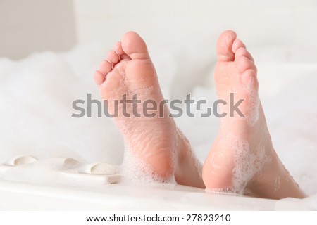 Closeup of feet on edge of bubble bath