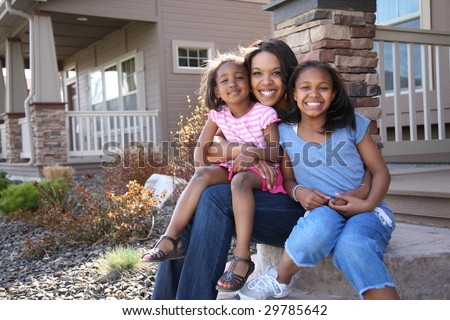 Portrait of mother and daughters sitting on porch