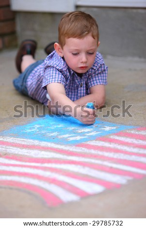 Young boy drawing American flag on sidewalk with chalk