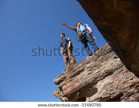 Two rock climbers standing on ledge