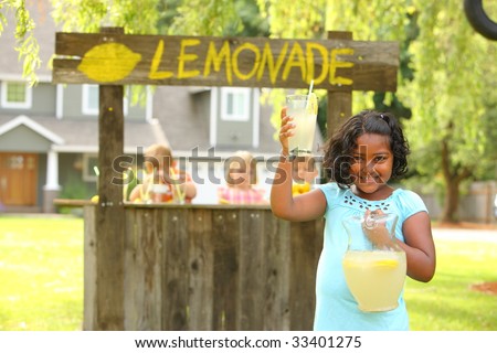 Girl holding lemonade in front of lemonade stand