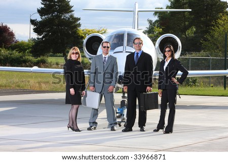 Group of business people with corporate jet in background