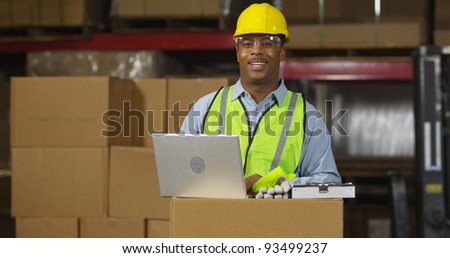 Portrait of worker in warehouse with laptop computer