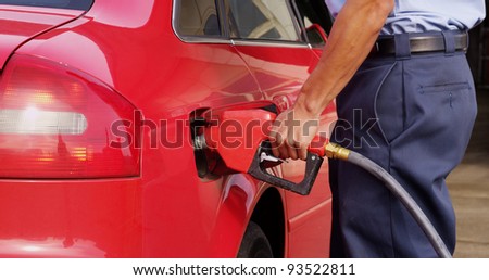 Gas station worker filling up car with fuel, closeup