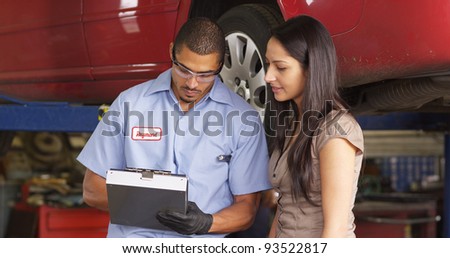 Auto shop mechanic works with customer