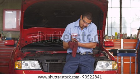 Auto shop mechanic talking on cell phone