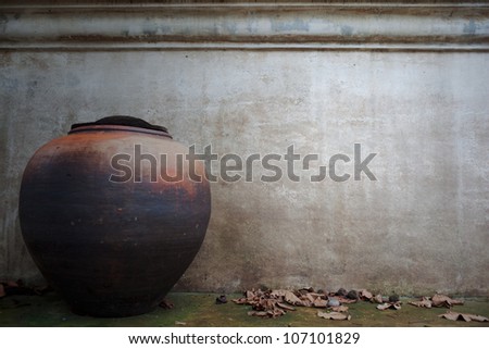 old grunge  concrete wall with clay jar